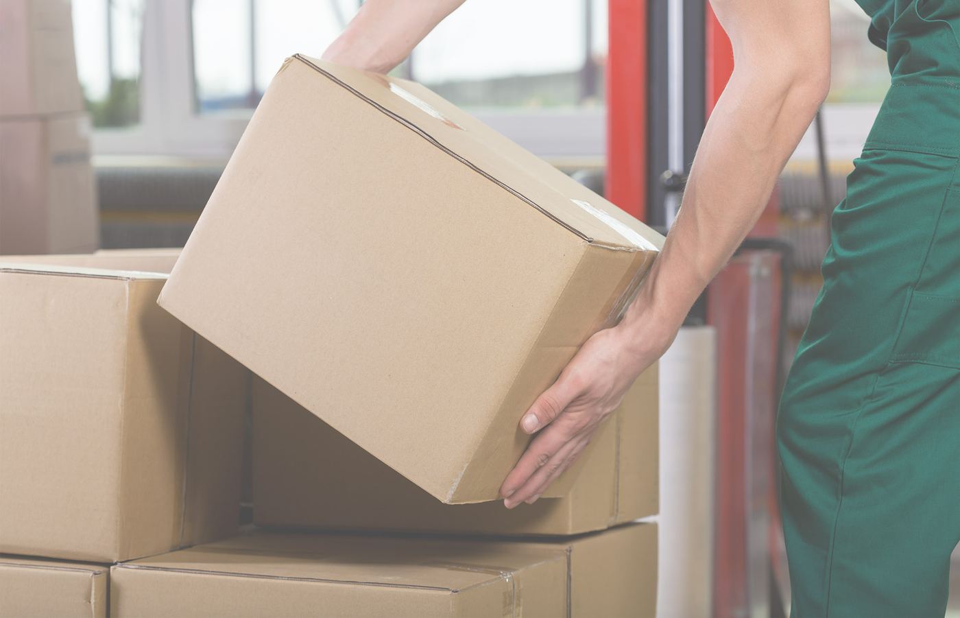Hands lifting a corrugated box from a stack