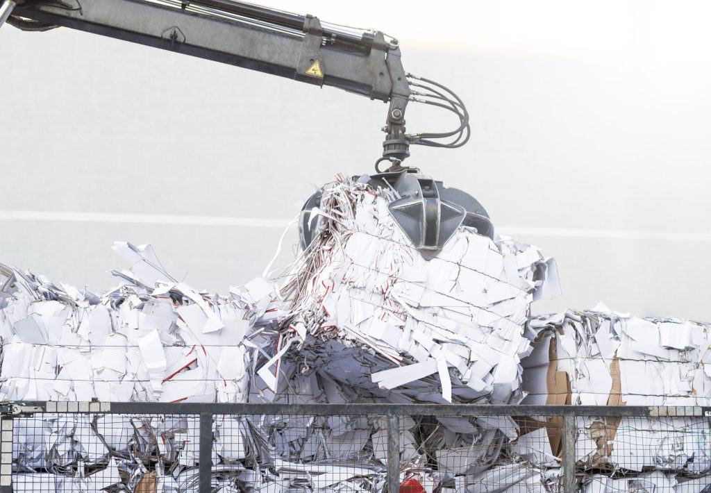Baled paper being lifted for repulping
